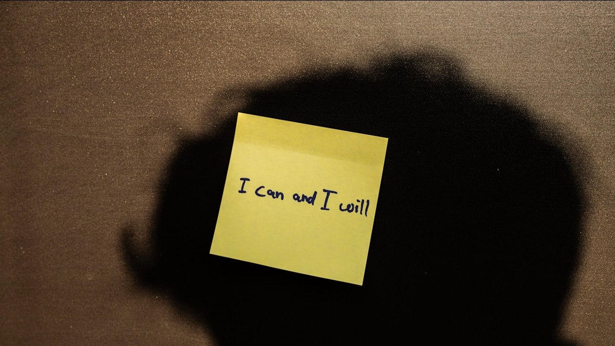 a sticky note attached to the back of a laptop